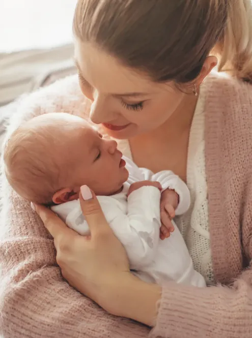 Postpartum Mental Health Support Mother holding and looking lovingly at her newborn baby