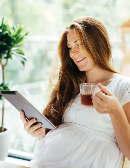 Pregnancy Wellness Planning Pregnant woman relaxing at home while using a tablet
