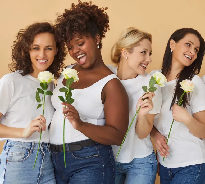 Mental Health Care for Every Woman Diverse group of women smiling and holding white flowers